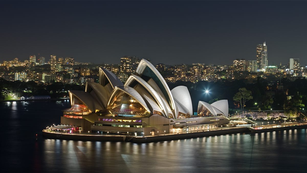 Sydney Opera House na baía de Sydney, Austrália, com arquitetura marcante e água ao fundo; experiência cultural e urbana imperdível.